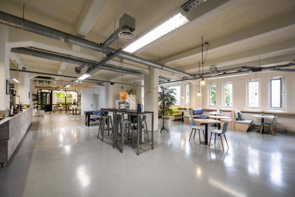 Modern coworking space on Van Diemenstraat with industrial design, shared tables, and cozy seating areas.
